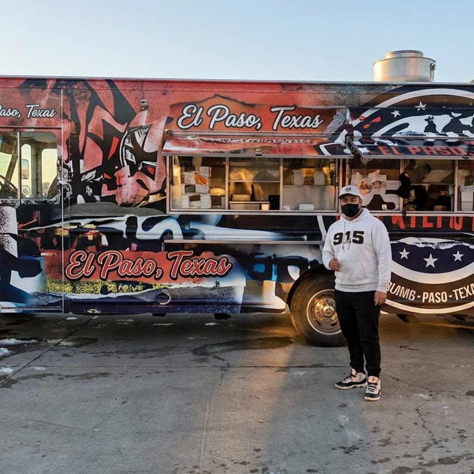 El Paso, Texas-themed food truck with serving window and masked person standing outside on a snowy day.